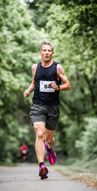 Hardloper Jacco rent op de weg onder bomen door